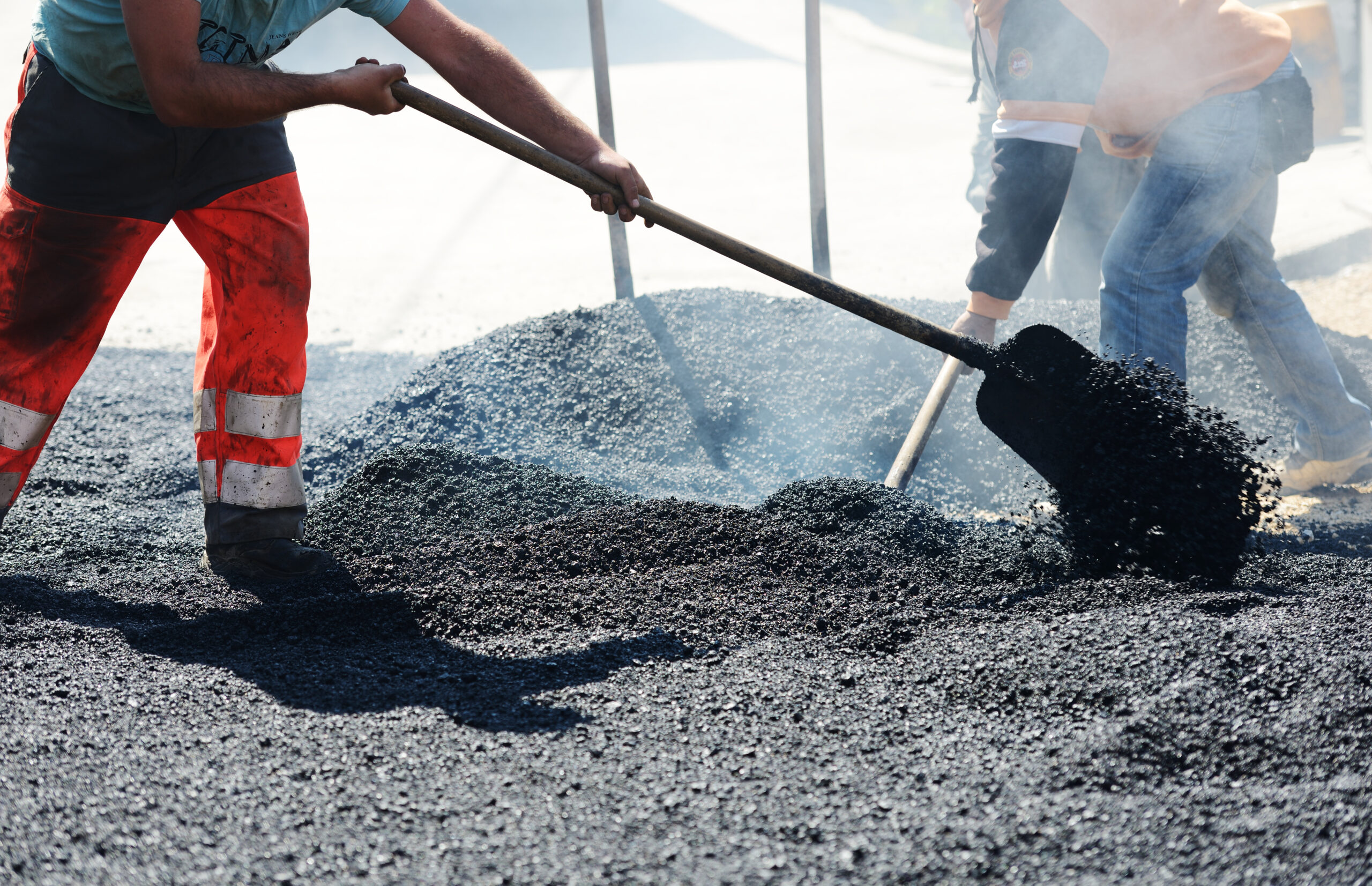 Men hard working on asphalting road